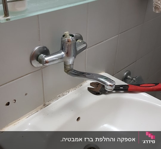 ברז כיור עם מפתח צינורות לתיקון